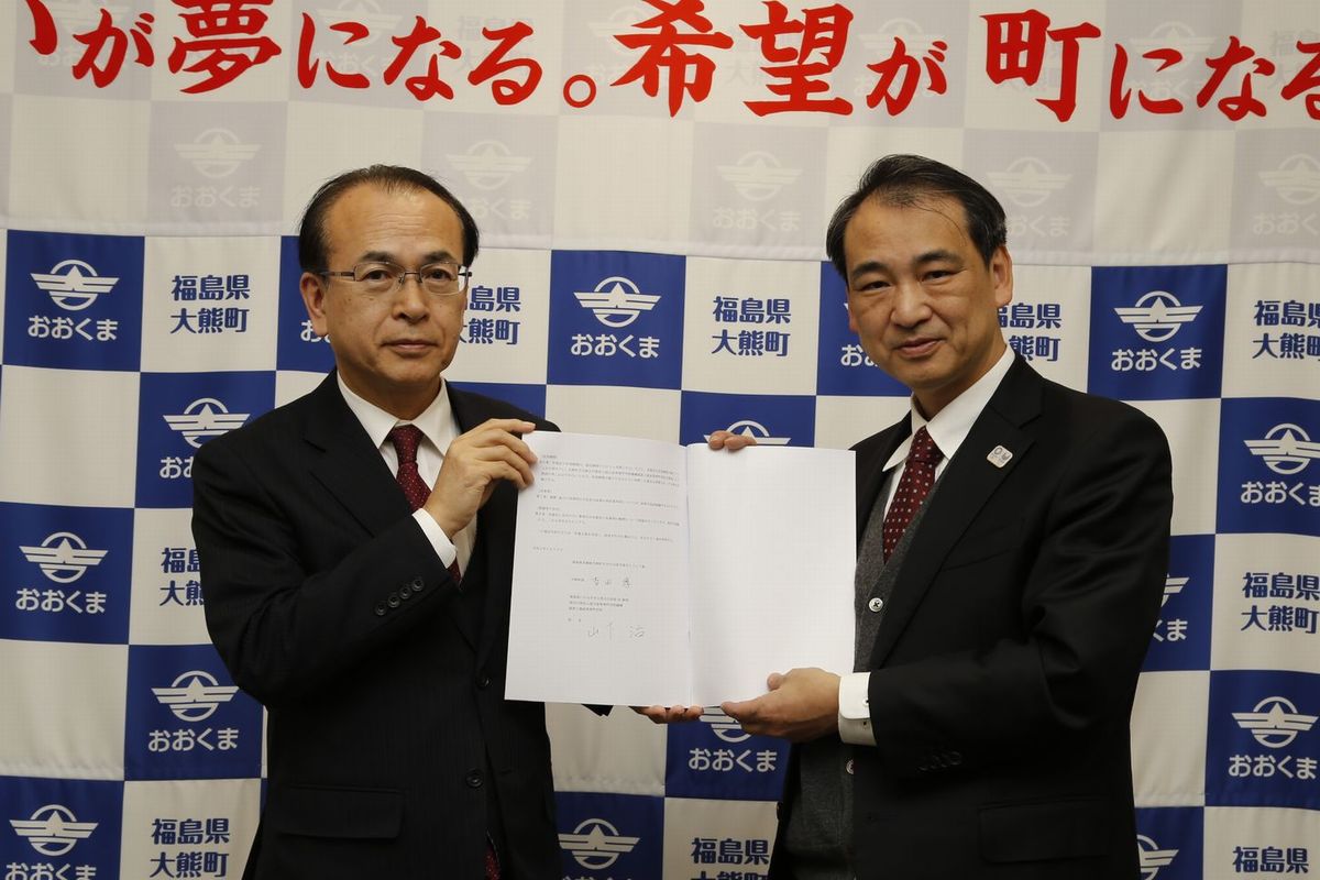 町と福島高専が連携協定を結び協定書を手にしている写真です