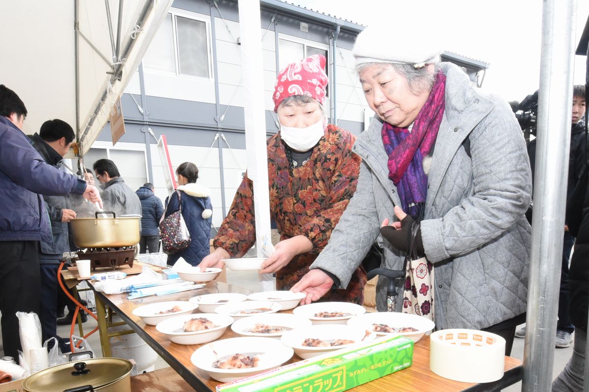 取り分けられたもちの皿を手にする女性