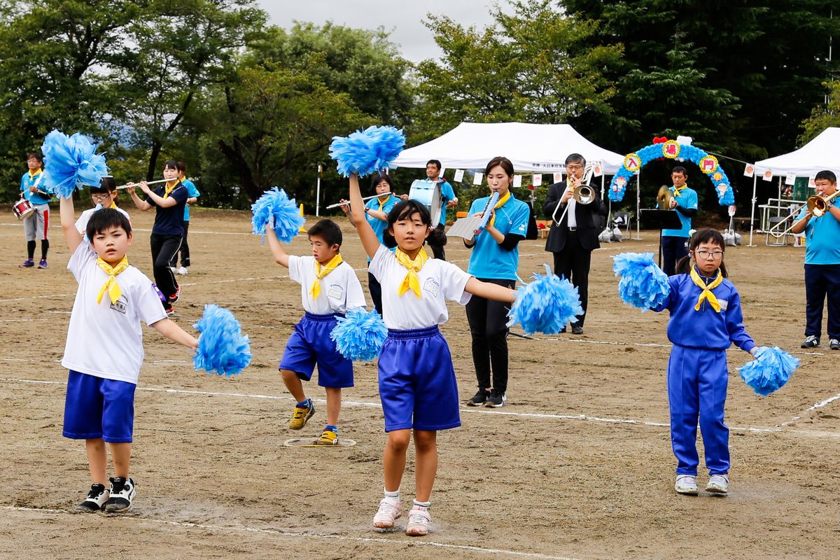 曲に合わせてポンポンダンスする児童