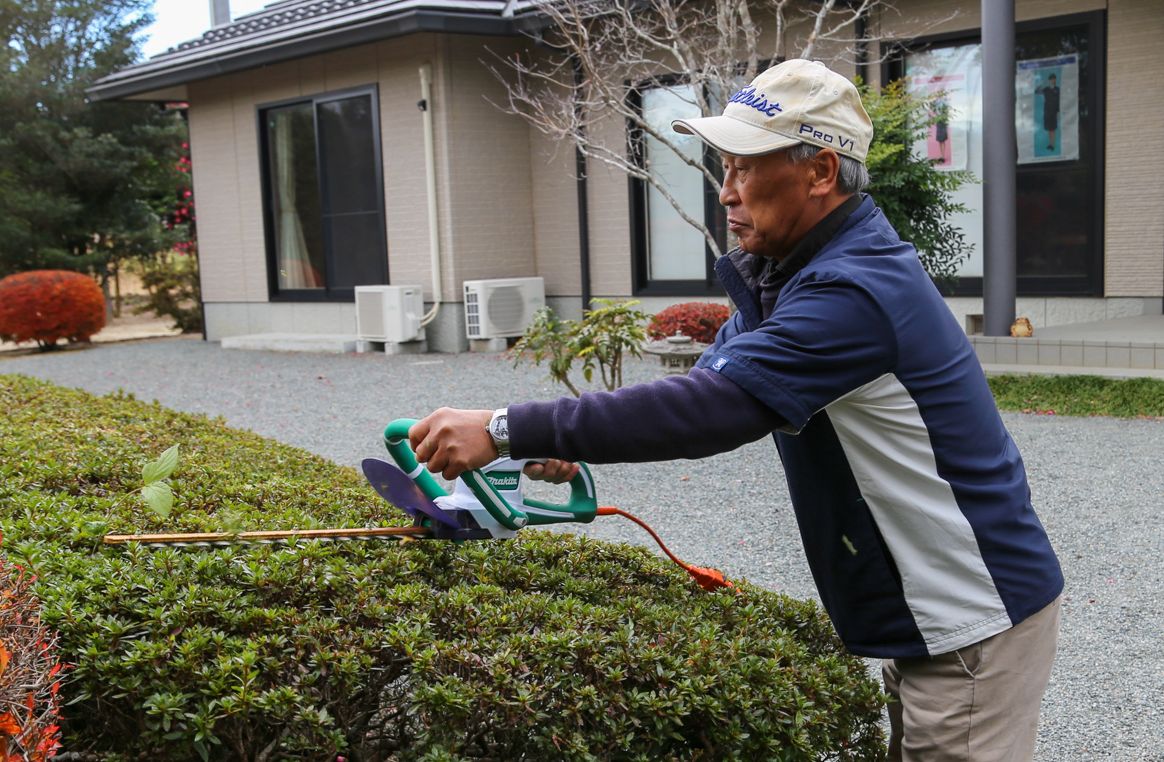 庭の手入れを行う高野さん