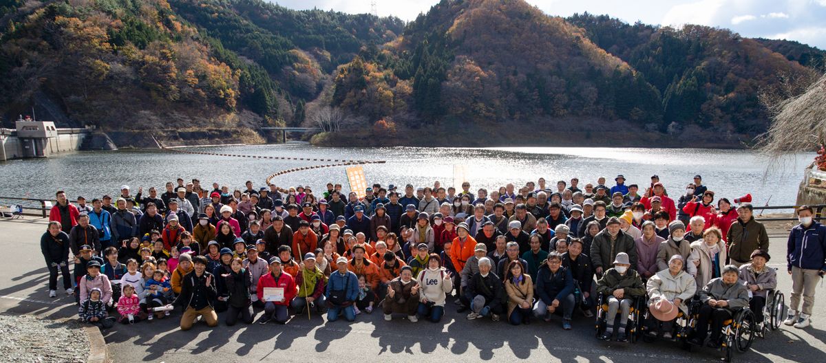 坂下ダムで記念撮影に収まる参加者