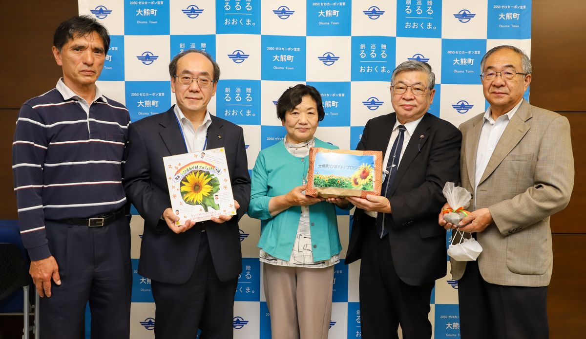 鈴木副理事長（右から2人目）から種を受け取る関係者