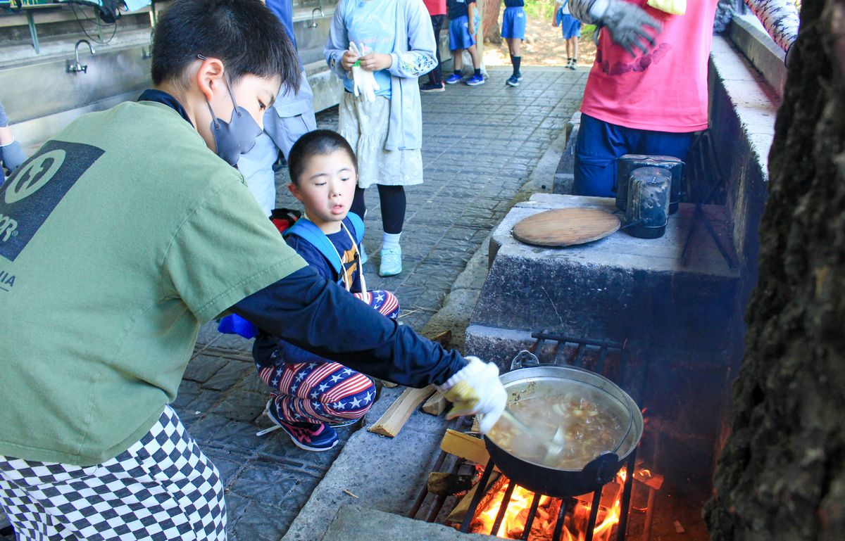 野外炊飯でカレーをつくる児童