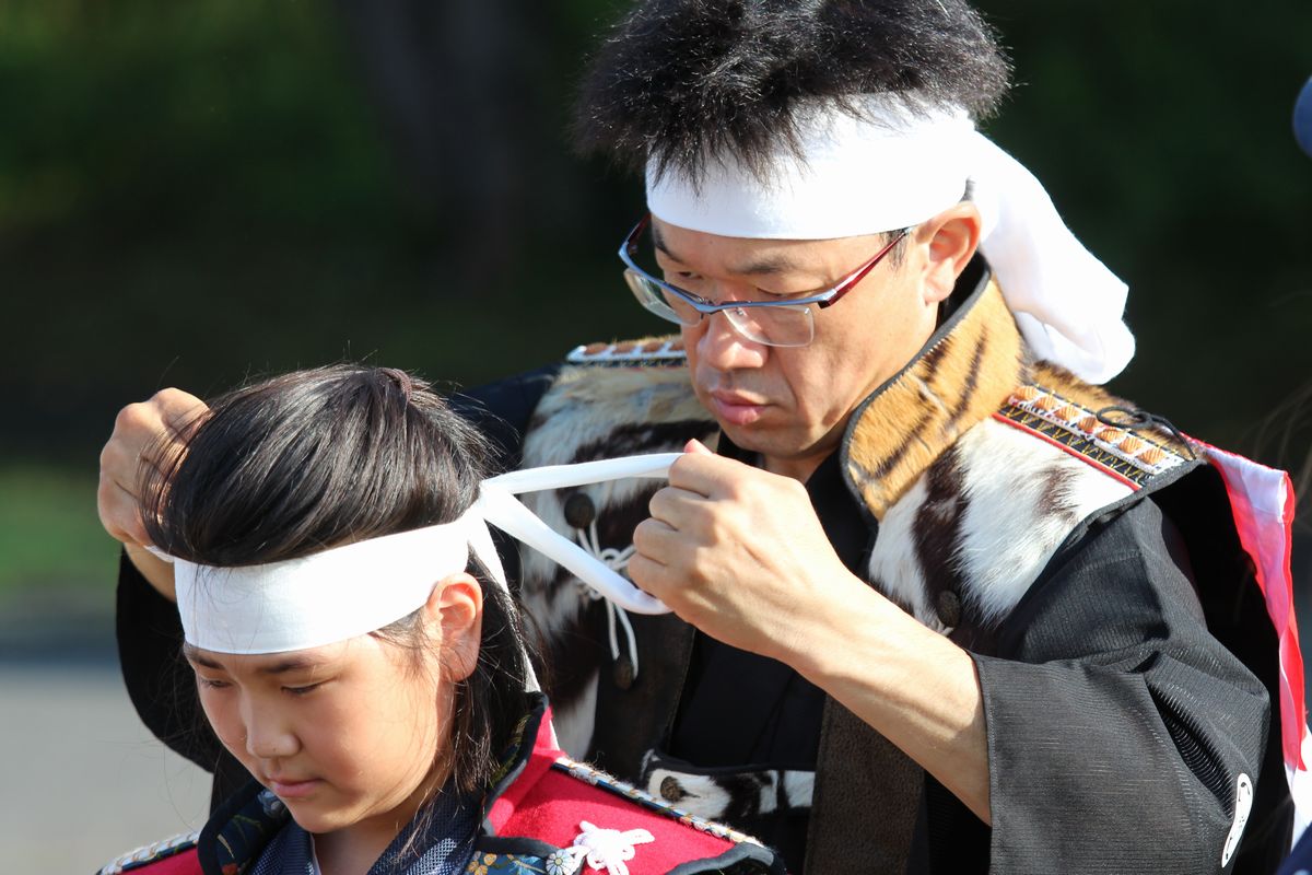 今年初陣を飾る騎馬隊船迫さんの白鉢巻きを締める町騎馬会小野田会長。