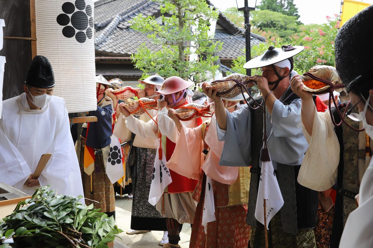 最終日、相馬小高神社境内で行われる野馬懸神事に参列する螺役・渡部さん。数人の螺役と共に境内にほら貝の音色を響かせました。