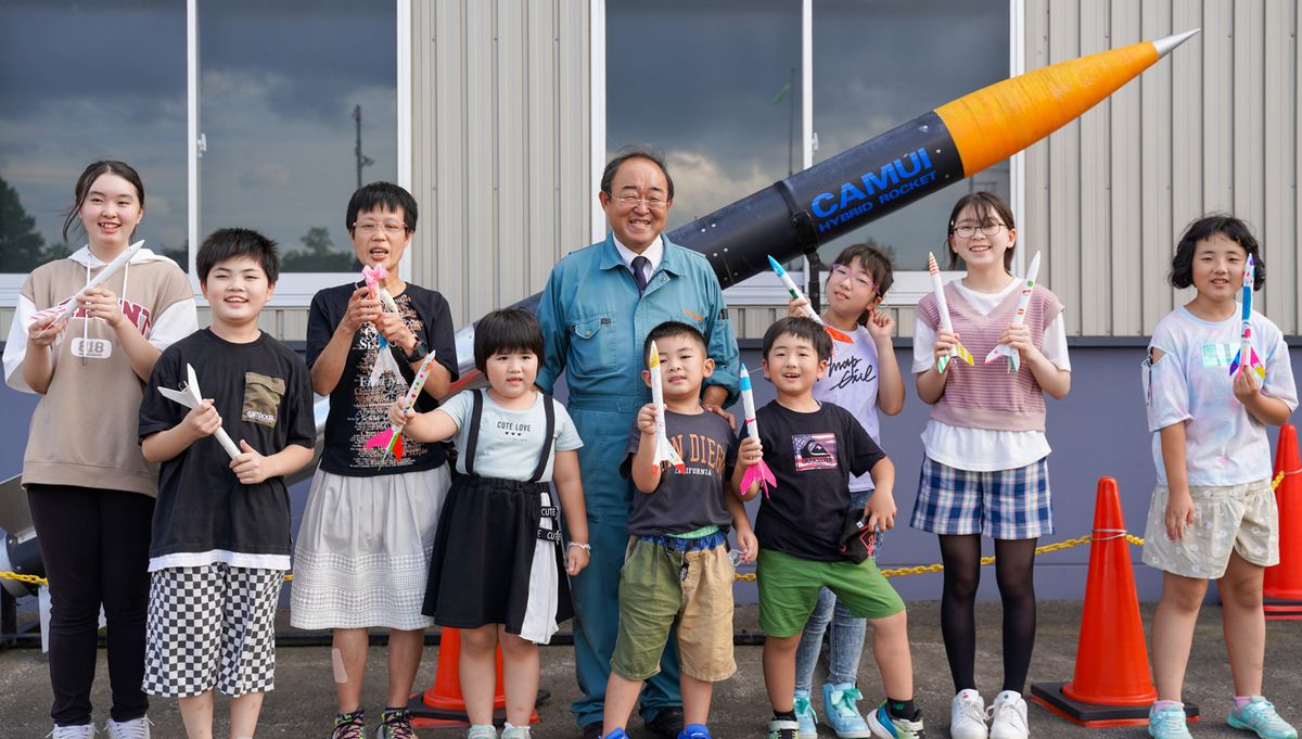 自作のロケットを手に記念撮影に収まる子どもたち