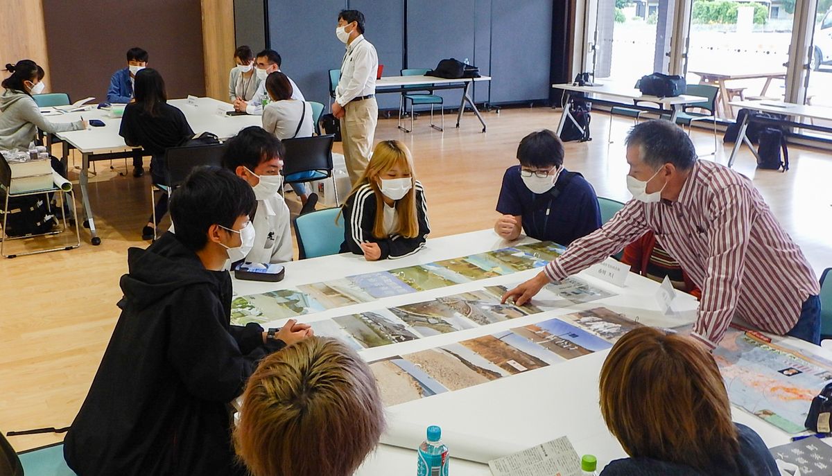 町民から震災後の町の話を聞く学生