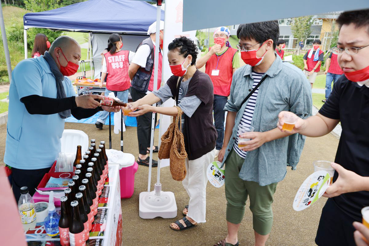 7月に数量限定で発売されたエールビール「いちご香るSOUR」を味わう来場者。ネクサスファームおおくまのいちごと田村市産のホップで作られ、いちごの豊かな香りと爽やかな酸味が味わえます。