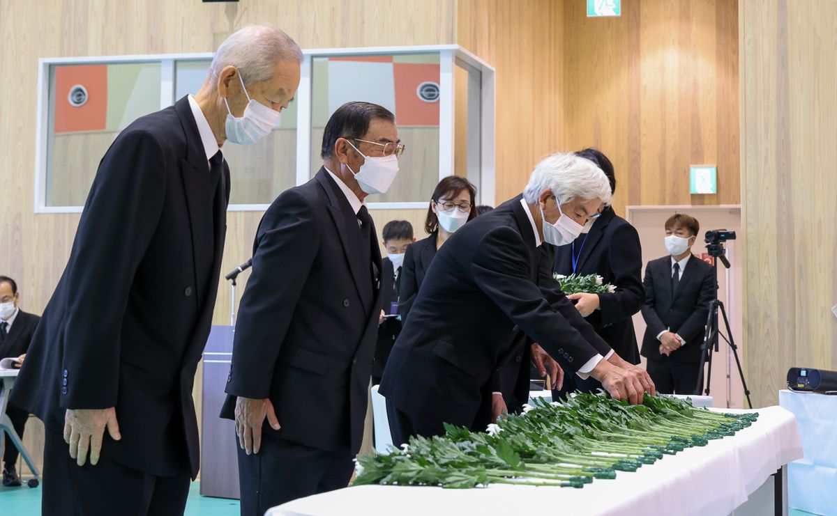 追悼式で献花を行う参列者