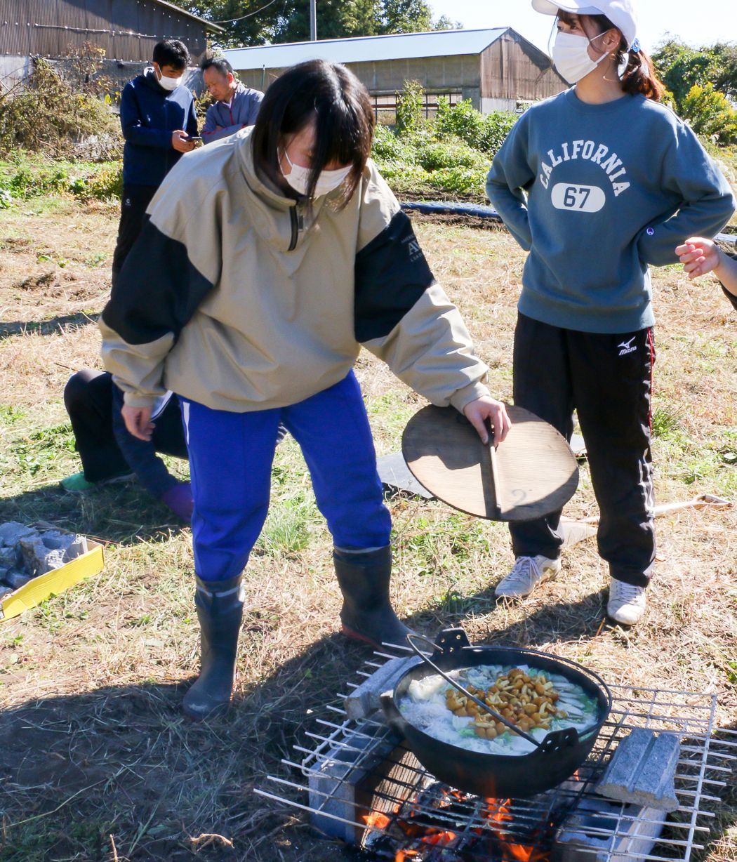 かまどで豚汁を煮る生徒