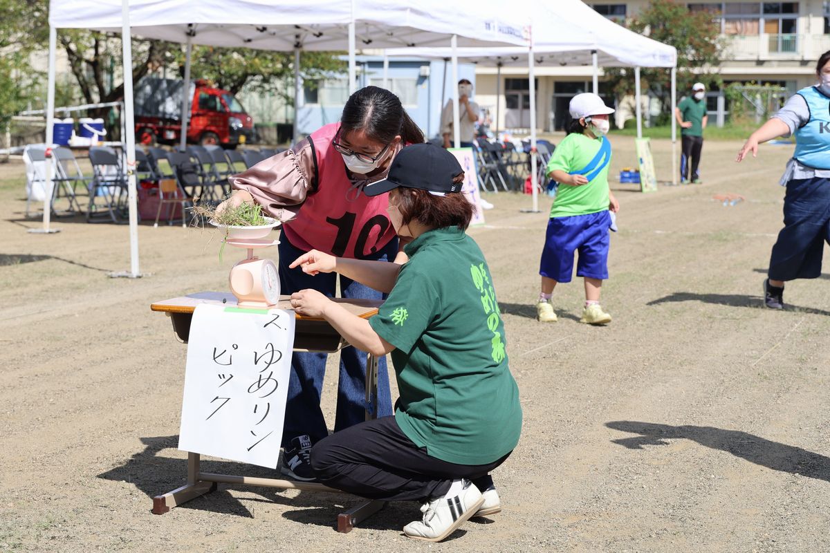 第1回ゆめリンピック！の種目で、走ってコース外の草むしりを行います。100～150グラムの範囲内で草をむしり、OKなら次の種目の人へつなぎます。草むしりが得意な地域の方はたくさんむしりすぎて戻す場面も。とてもユニークな種目です。