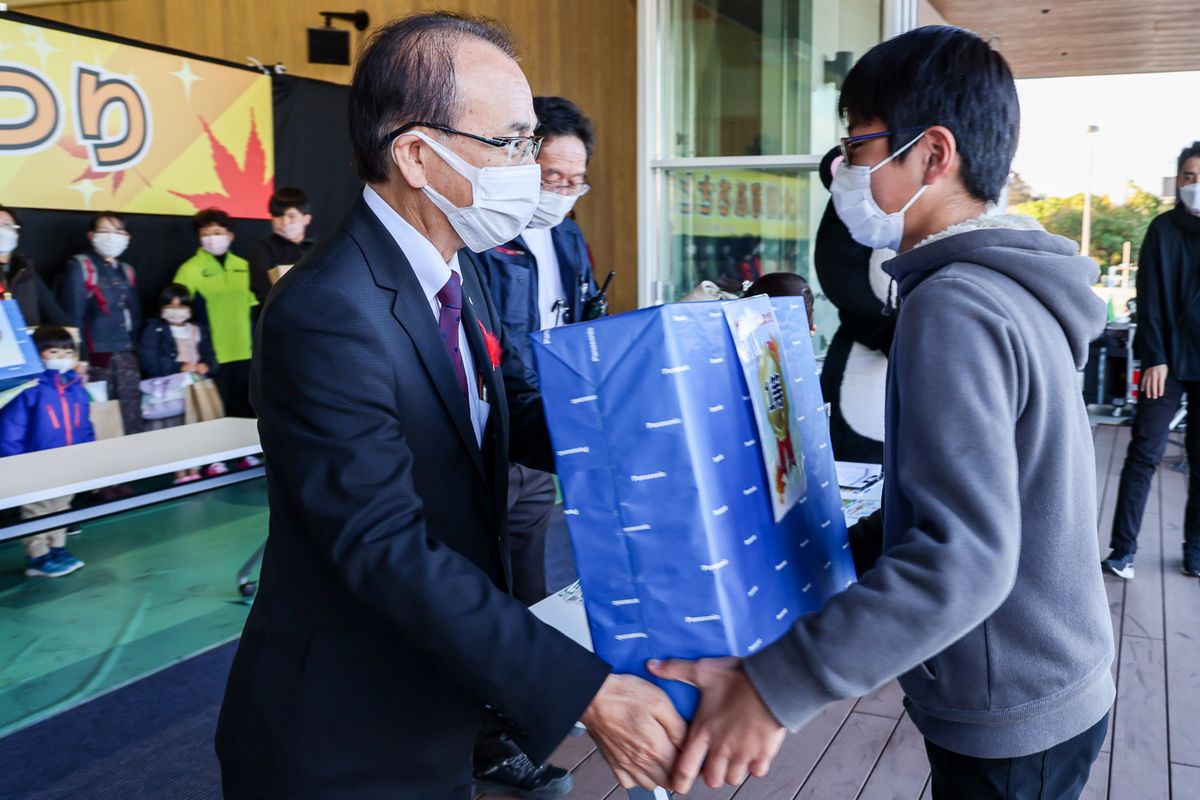 豪華景品が当たる大抽選会で、吉田町長から1等景品を受け取る当選者。