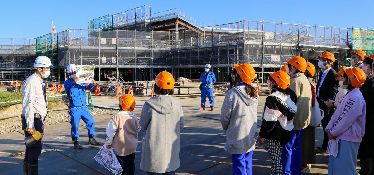 建設中の教育施設を見学する児童生徒