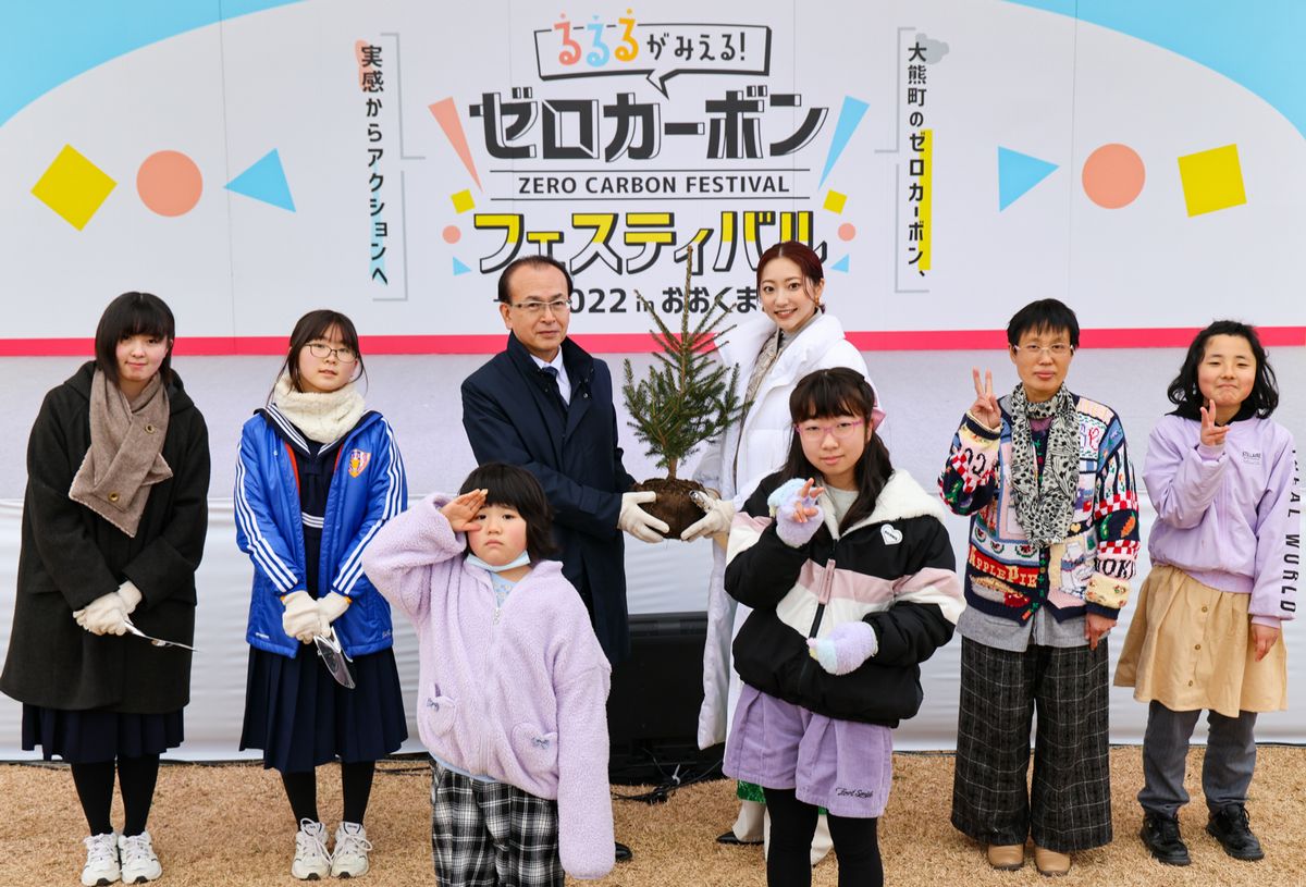 植樹に臨む吉田町長と武田玲奈さん、町立学び舎ゆめの森の児童生徒ら