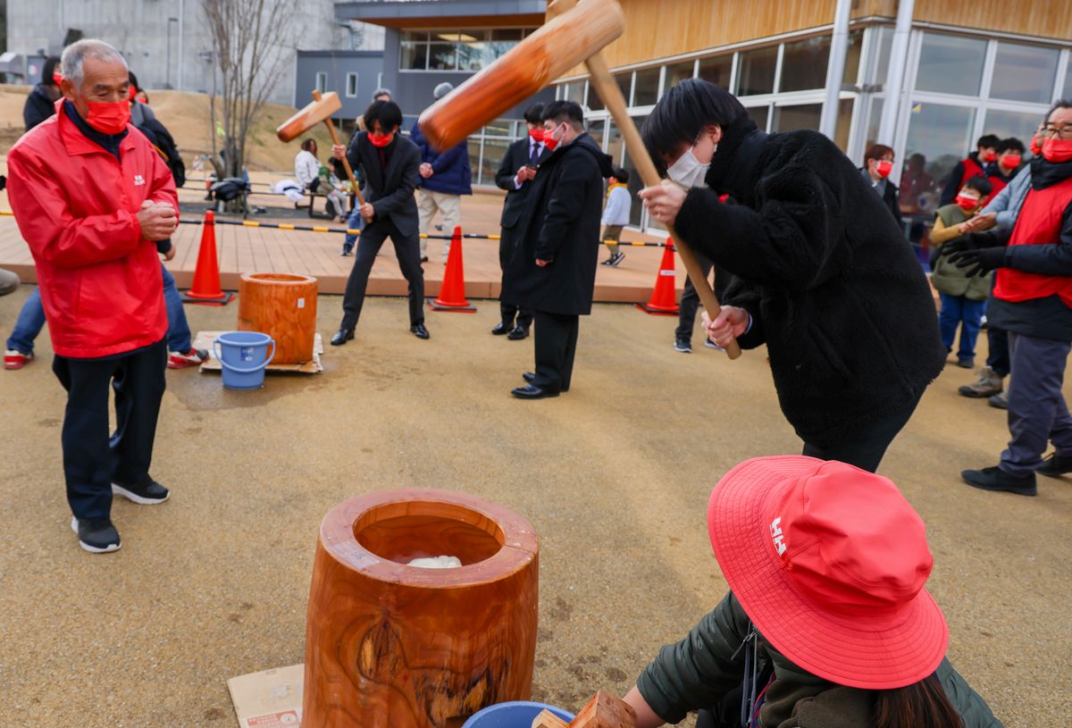 スーツ姿でもちつきに参加した成人式出席者