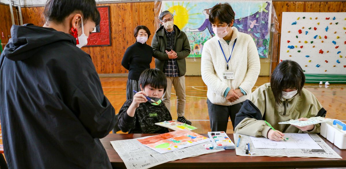 蟹江さん（左）と作品制作に取り組む児童生徒