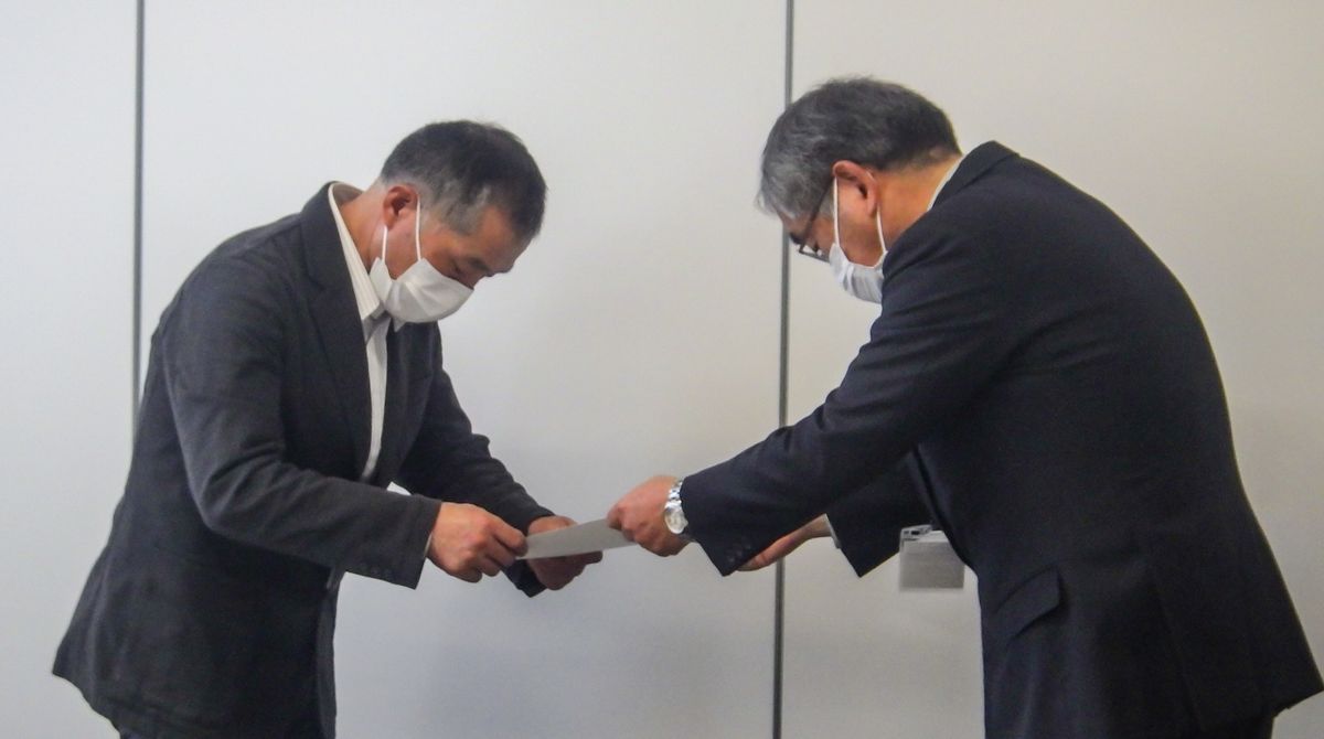松岡教育長職務代理者から委嘱状を受け取る委員（左）