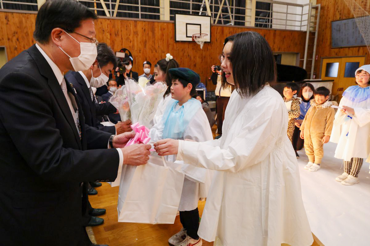 室井市長（左）や支援者らに花束を渡す子どもたち