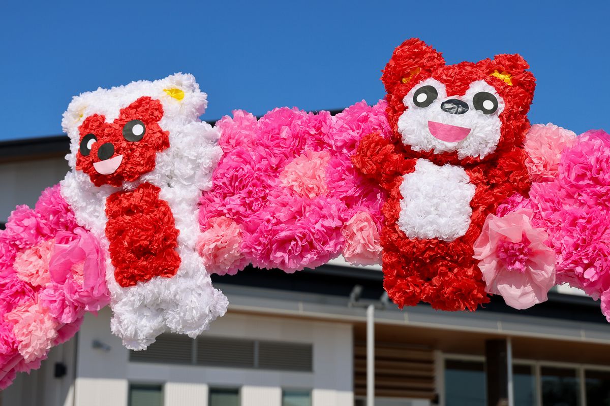 出迎えの花道に用意されたアーチには、お花紙で作ったふわふわの花や花で形作った熊が飾られ、子どもたちは嬉しそうにくぐりました。