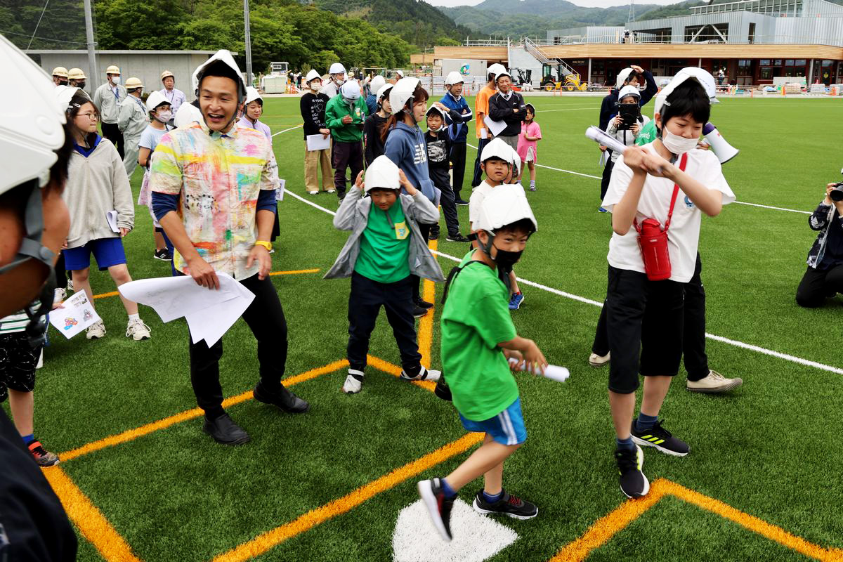 グラウンドの一角に野球のホームベースを見つけた子どもたちは、持っていた紙をまるめバットのように勢いよく振り上げていました。