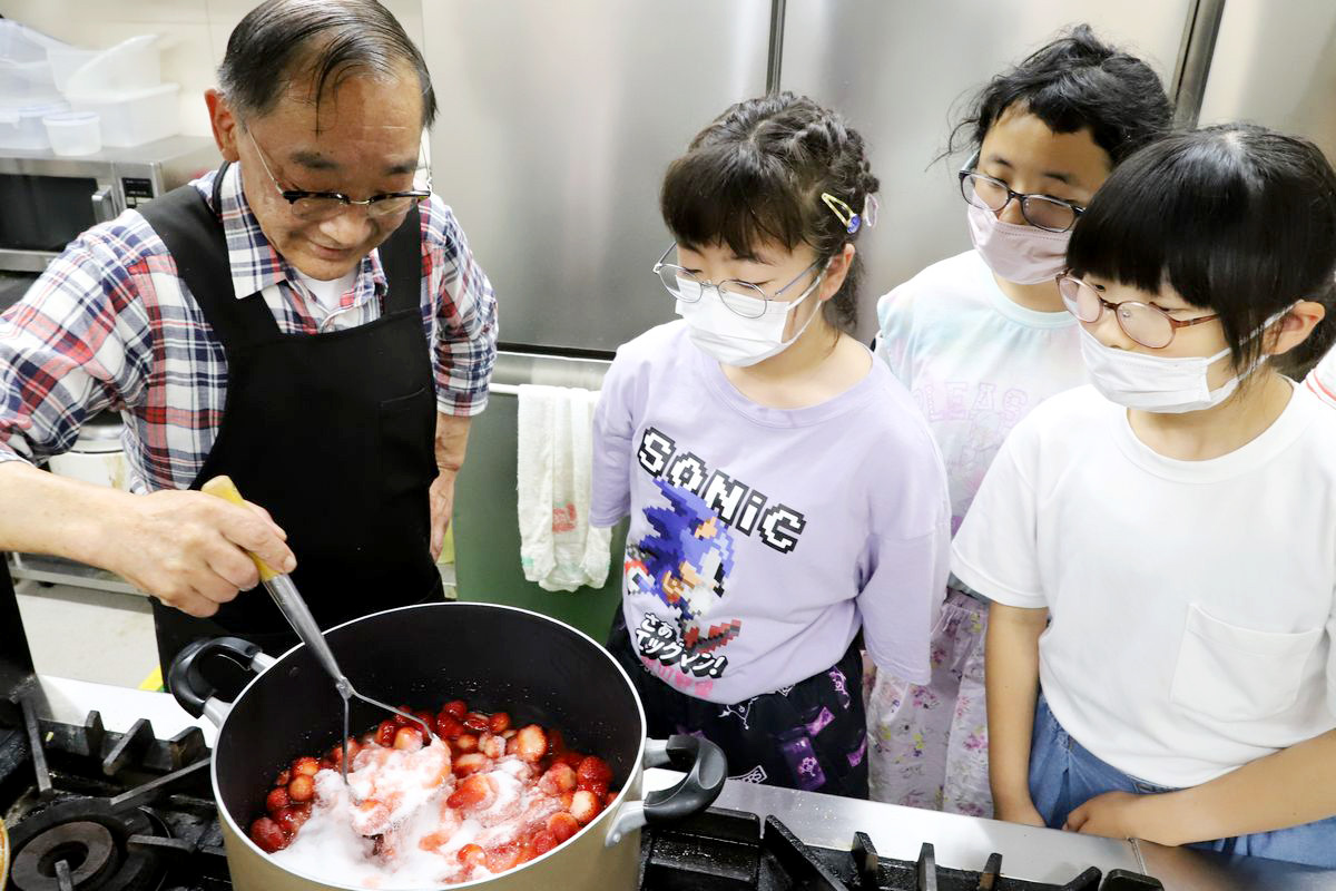 ヘタを取ったイチゴを寸胴鍋に入れ計量した砂糖と混ぜ合わせ火にかけます。子どもたちは、ジャム作りの工程を見逃さないよう鍋の方をじっと見つめています。