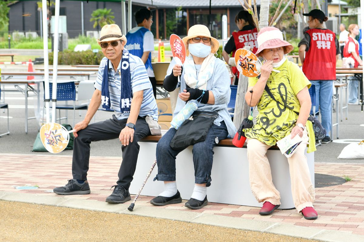 受け付けで配布された「祭」のうちわを持つ来場者。