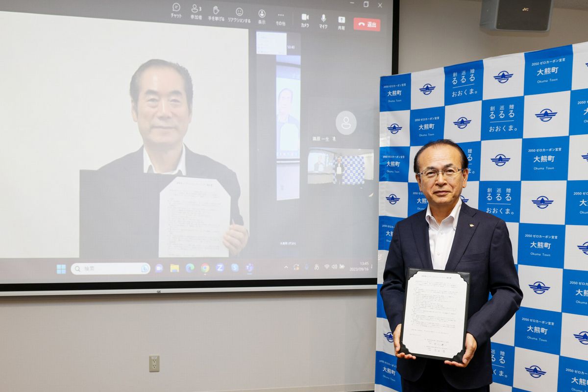 協定書を掲げる白川市長（左）と吉田町長