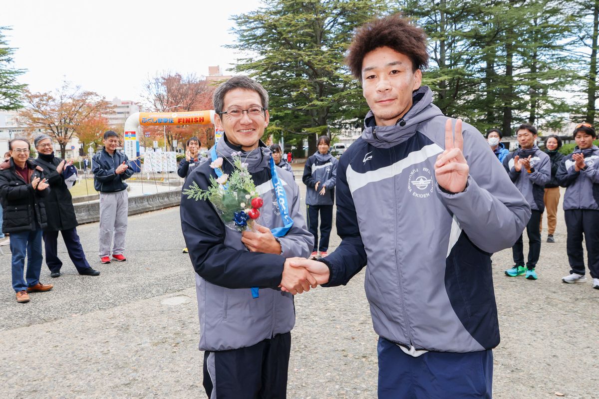 花束を受け取る渡辺監督（左）