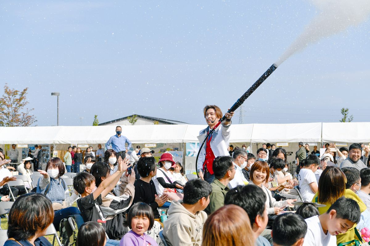 ゼロカーボンフェスティバル2023inおおくまが10月28日、大熊町役場前広場で開催され、約1,300人が来場しました。写真は、市岡元気さんが科学実験で降らせた雪に歓声をあげる来場者らの様子。