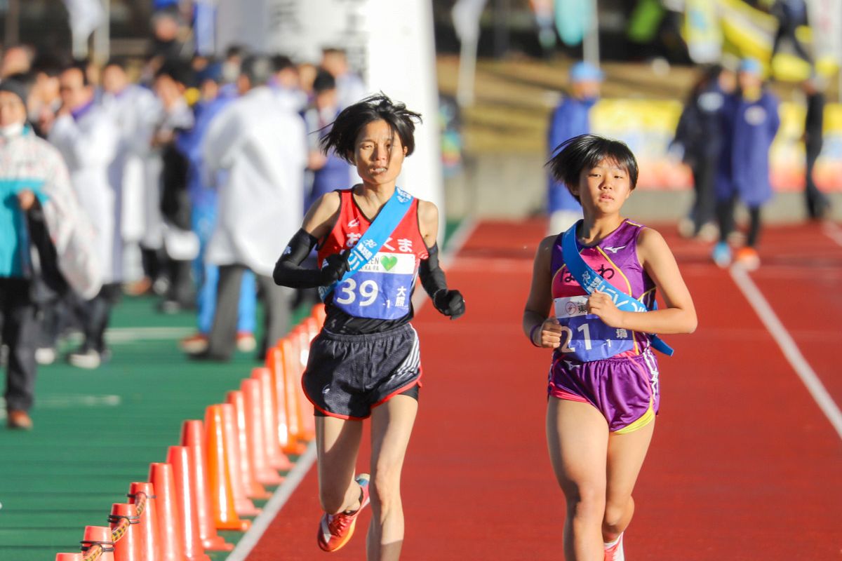 大熊町チームは今大会で35回目の出場。第1回大会から単独チームでの出場を続けており、今回も単独出場を果たしました。写真は1区4kmを走る渡辺友美選手（左）。午前7時40分、しらかわカタールスポーツパーク（白河市総合運動公園）陸上競技場をスタートしました。