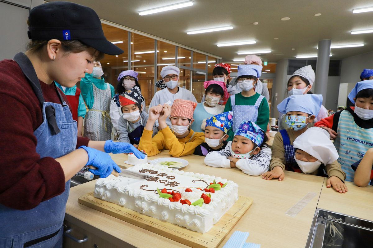 特大ケーキを切る池田さん（左）