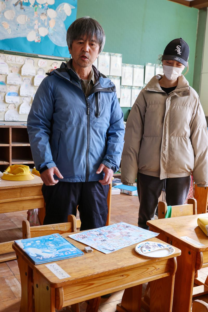 木村汐凪さんの机の前に立つ父の紀夫さん（左）と姉の舞雪さん（右）