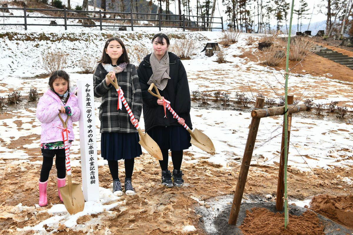 植樹した卒業生は「100年先も震災が忘れられないように、桜が町の復興のシンボルになってほしい」と話しました。写真は植樹を終えた卒園児と卒業生の3人。