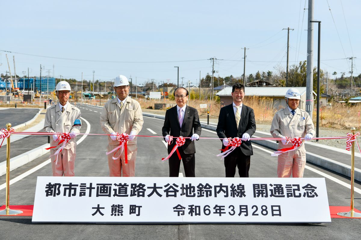 道路の開通を祝いテープカットする吉田町長（中央）