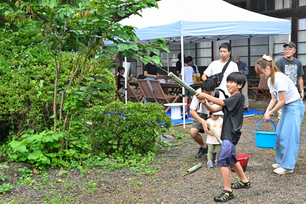 自分で作った竹の水鉄砲で遊ぶ子どもたち