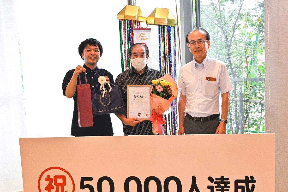 来館5万人目となった菊地さん（中央）