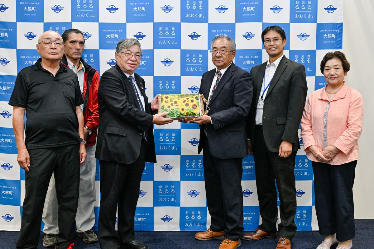 ヒマワリの種を受け取る鈴木さん（左から4人目）