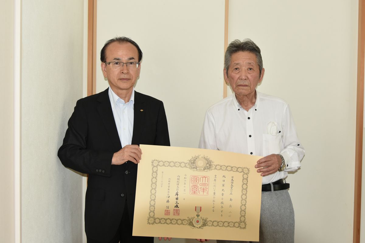 叙勲授与に記念撮影する吉田町長と広島さん（右）