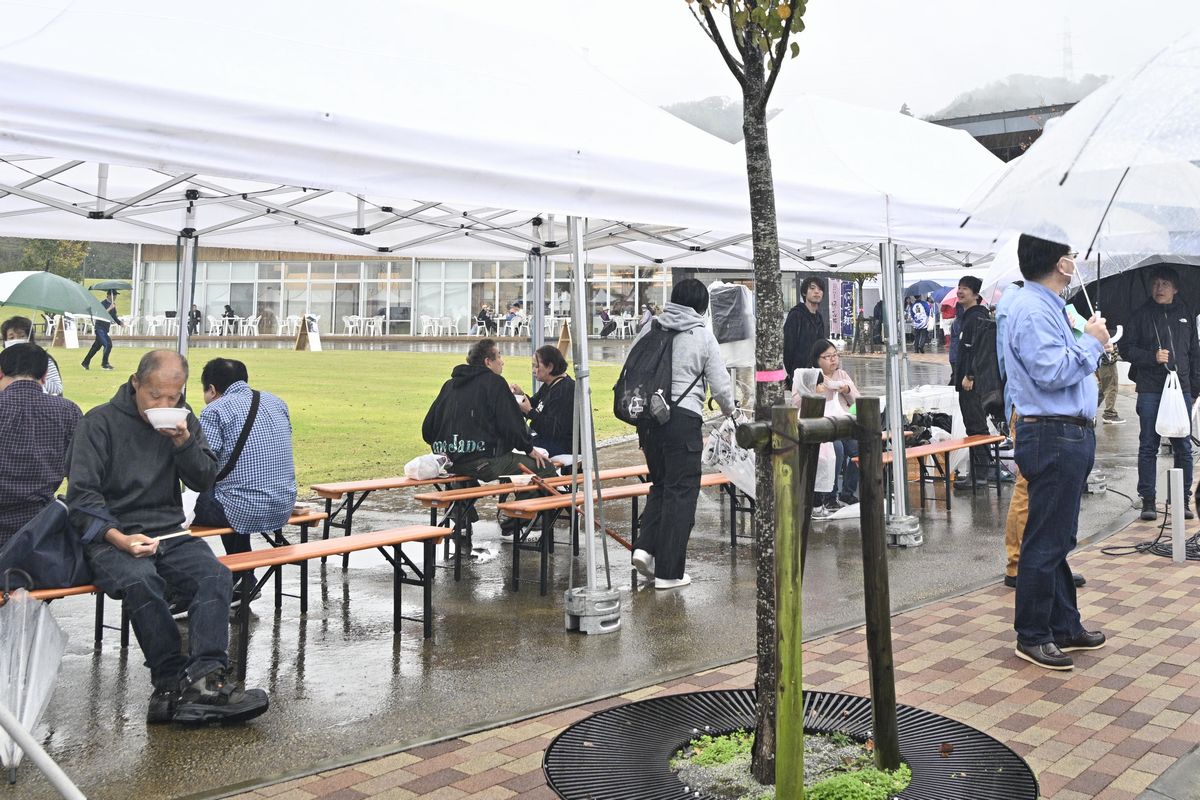 役場前広場のテントで食事をする来場者。