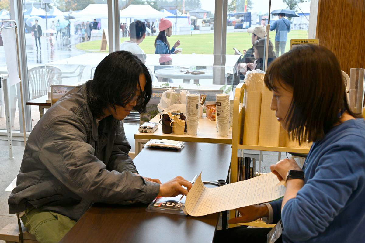 ふるさとまつり当日は町役場多目的ホールで開催していた文化展の最終日。町民の皆さんや学び舎ゆめの森の子どもたちの作品展示の他、当日のみ行われた体験イベントがありました。写真は、図書館司書の仕事を体験するブックコート（本の表紙にフィルムを貼ることで、汚れや破れを防ぐ）の体験講座。