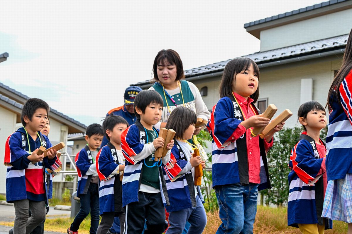 防火パレードで拍子木を打つ園児たち