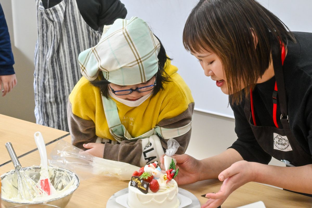 クリームの絞り方のコツを教わる様子