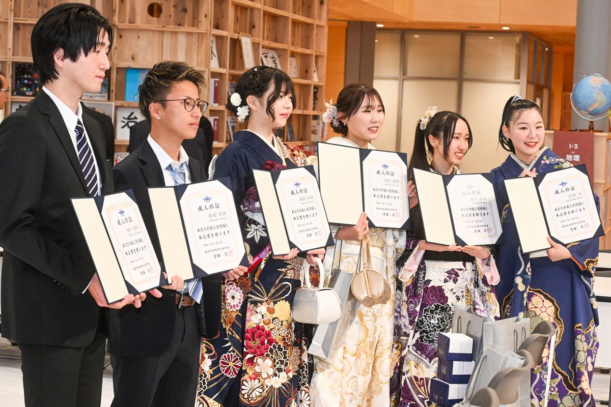 式典終了後、出席者たちは「成人の証」と書かれた証書を開き、記念撮影に応じました。