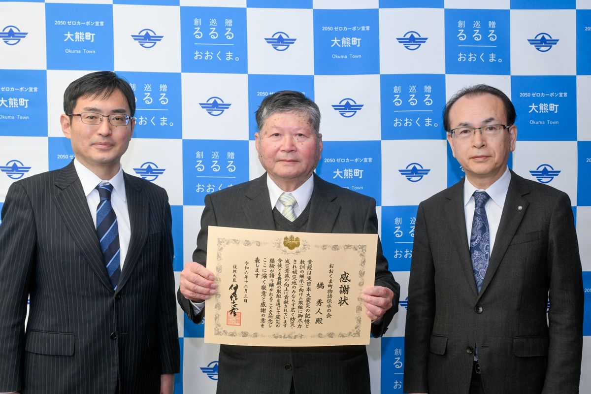 志田局長（左）から感謝状を手渡された橘さん（中央）