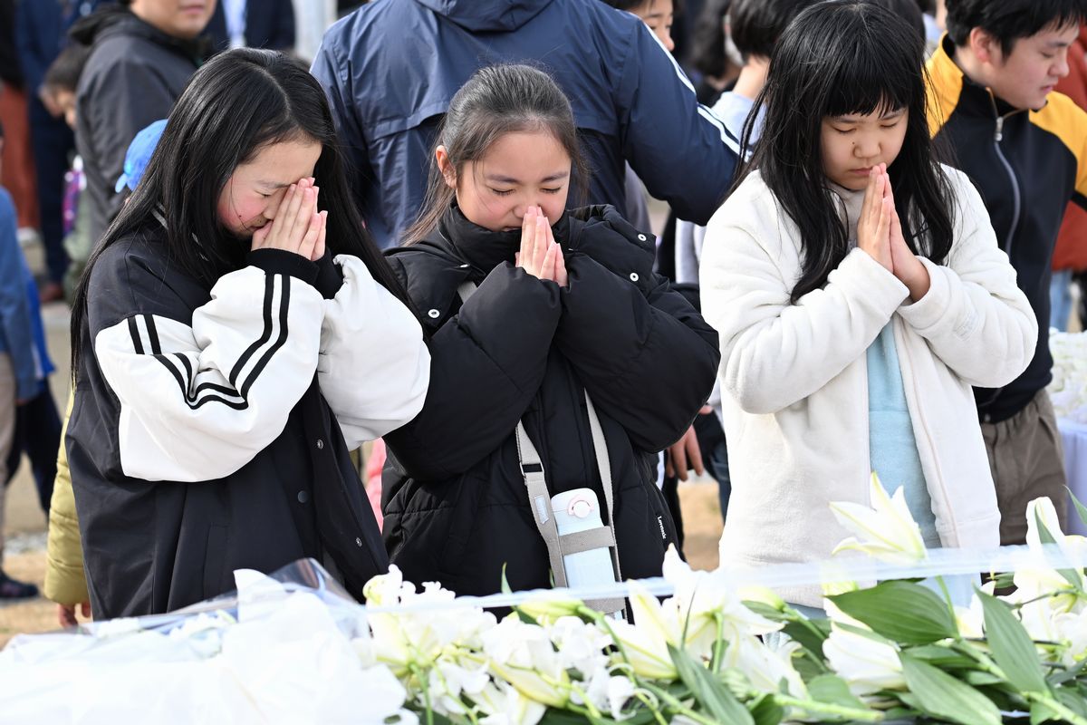 献花台の前で祈る学び舎ゆめの森の子どもたち