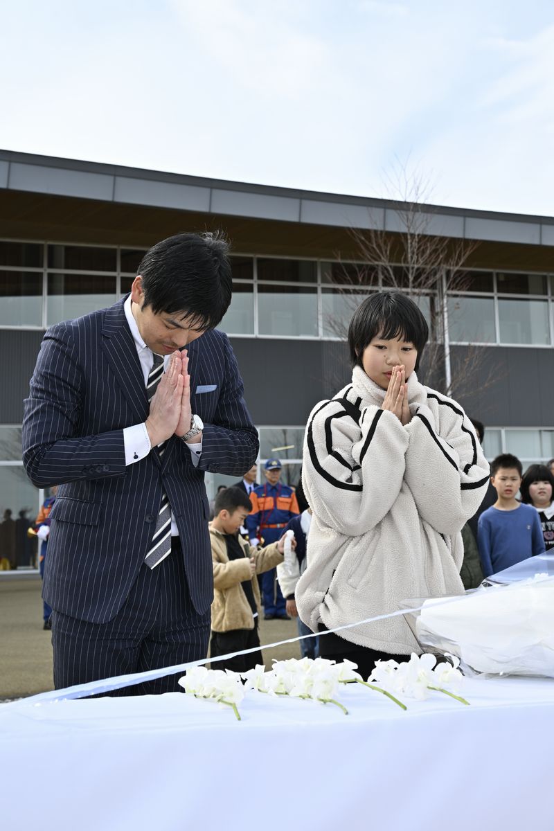 献花台の前で手を合わせる学び舎ゆめの森の児童。