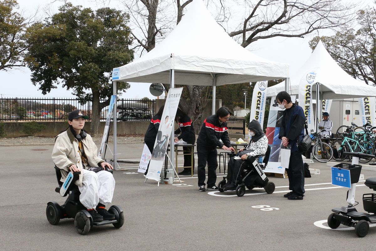 「ゼロカーボンフェスティバル」のエリアでは、CO₂を排出しない車両やEVに改造されたクラシックカーが展示され、体験型ワークショップも好評でした。写真は、来場者が電動車椅子に試乗する様子です。
