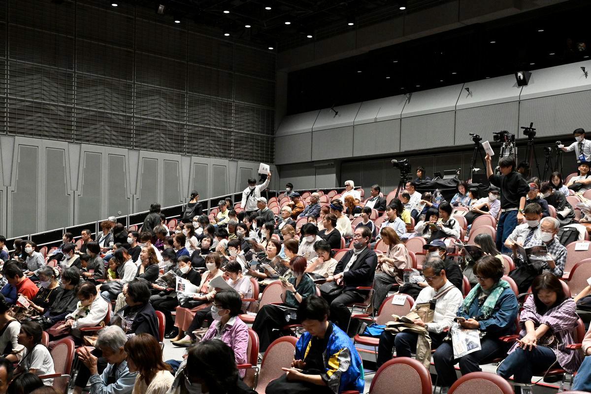 客席には多くの観覧者が集まり、手元のチラシに目を通しながら、開演の瞬間を待っています。