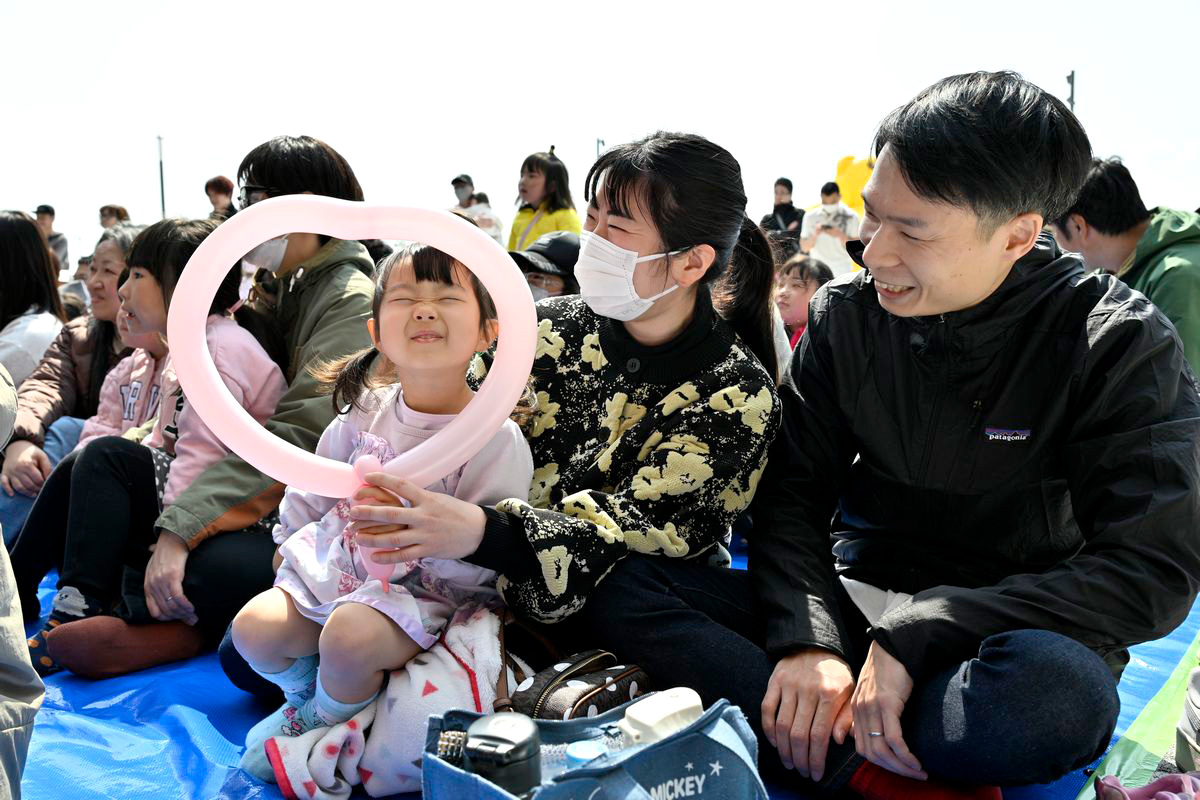 笑顔でステージショーを観覧する親子。楽しんでいる様子が伝わり、会場は温かな雰囲気に包まれていました。