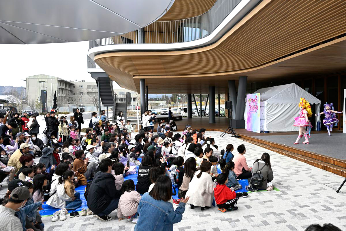 駅西交流エリアは地域の交流拠点として賑わい、今後も多彩なイベントが開催される予定です。写真はCREVAおおくま正面エントランスで行われたステージイベントの様子。子どもたちに人気のプリキュアショーとあって、多くの親子連れで賑わいました。